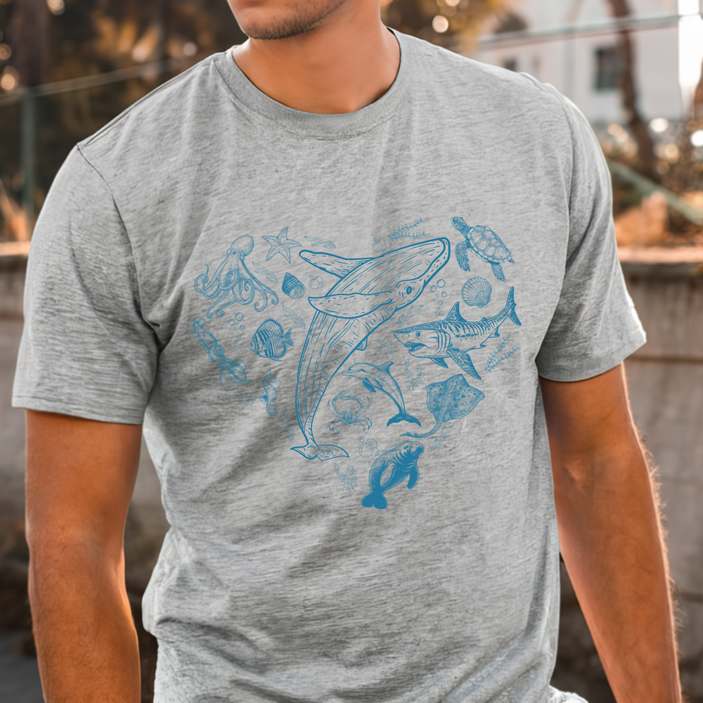 Person wearing a gray t-shirt with blue whale and fish illustrations.