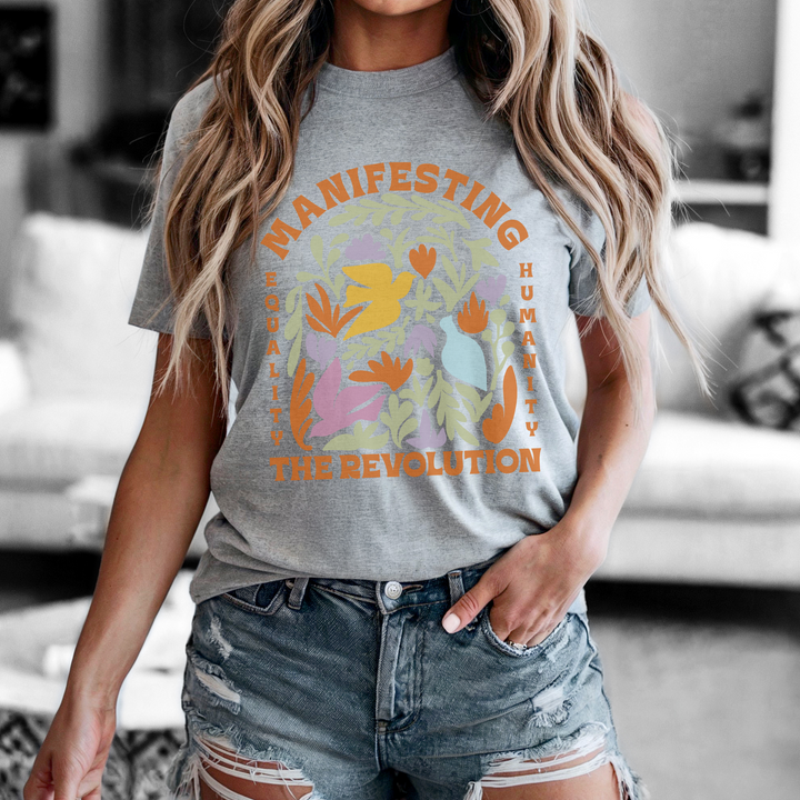 Person wearing a gray t-shirt with a colorful graphic and text.