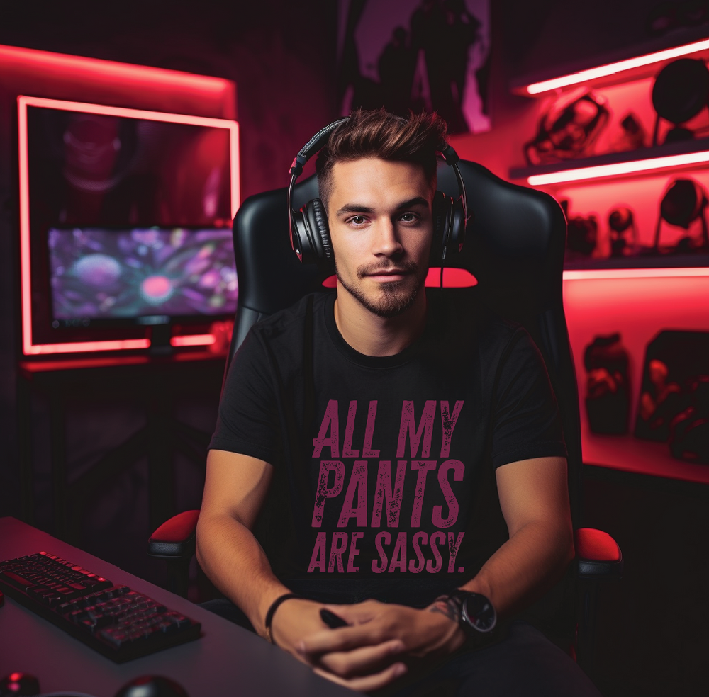 Young man with gamer headphones wearing a short sleeve black tee with “All My Pants Are Sassy” graphic.