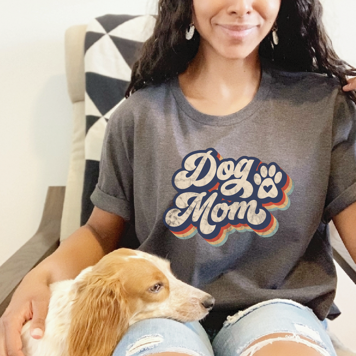 Woman in tee with “Dog Mom” graphic, petting her dog.
