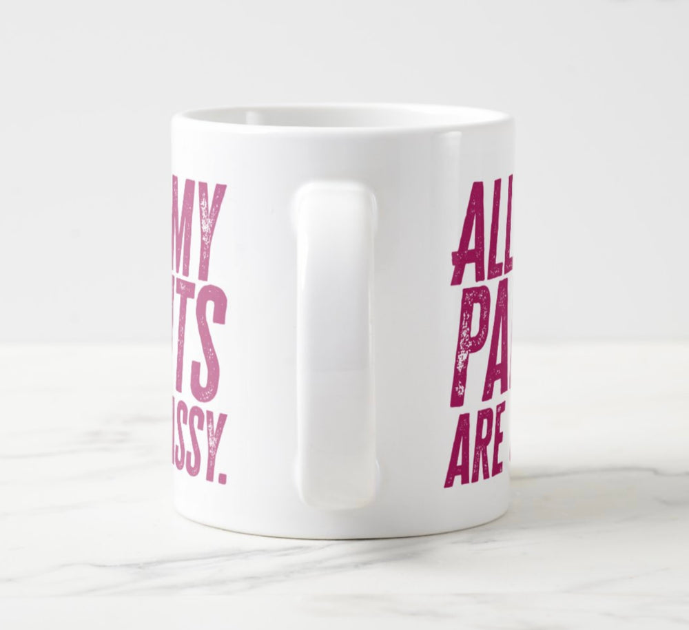 Photo of large white mug, with hot pink tet saying “All My Pants Are Sassy”.