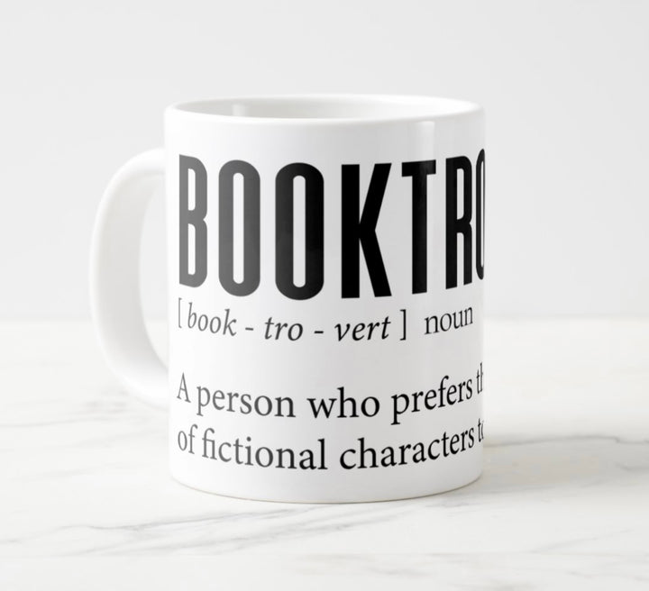 Large white mug with graphic: “Booktrovert: Book-tro-vert, noun. A person who prefers the company of fictional characters to real people.”