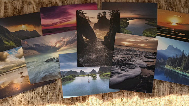 Assorted greeting cards with photographs of water-based landscapes on a natural fiber background.