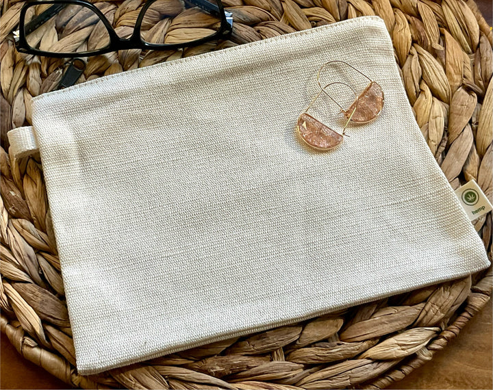 Beige pouch with sunglasses on a woven surface