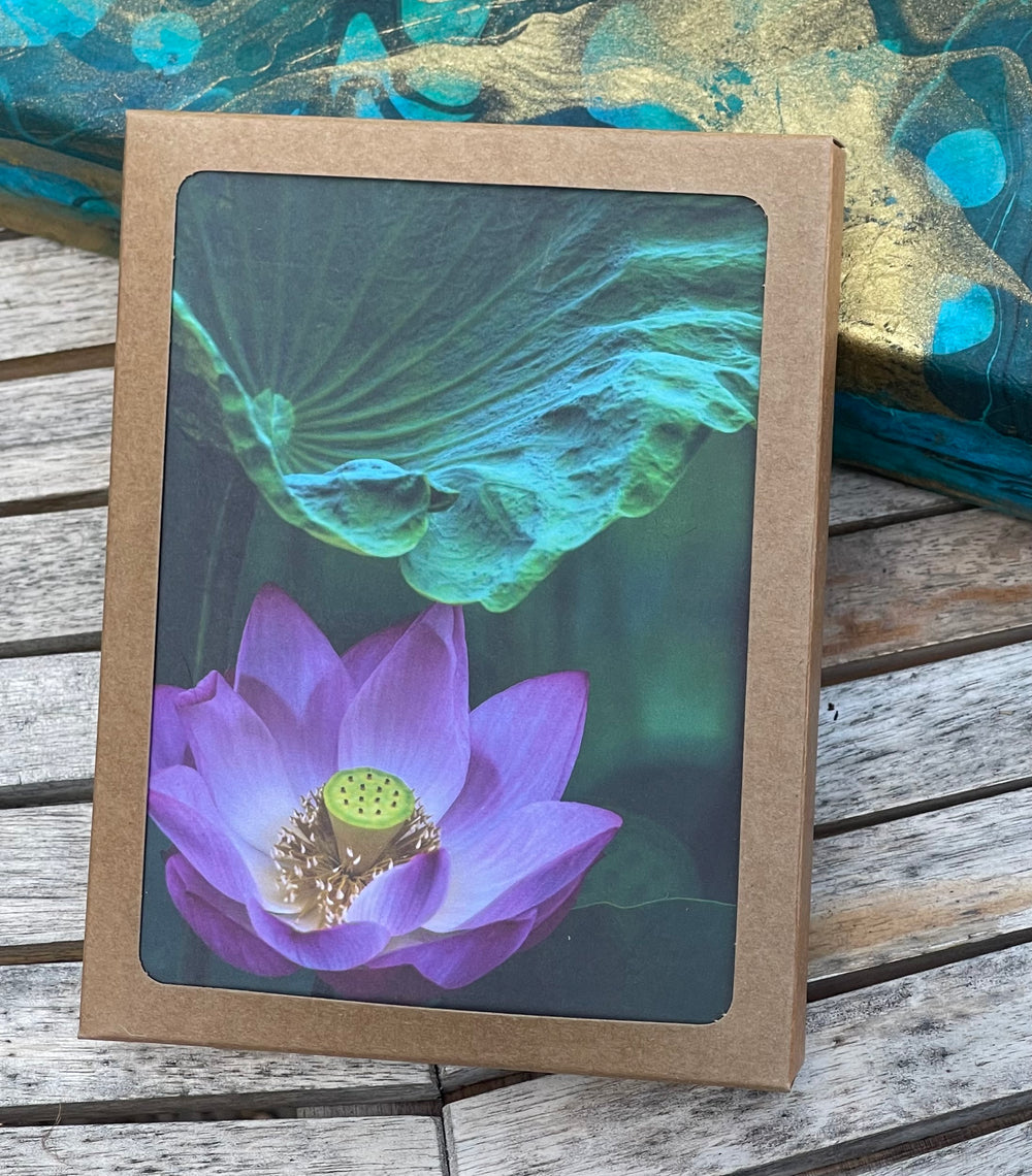 Framed artwork of a purple flower on a wooden surface