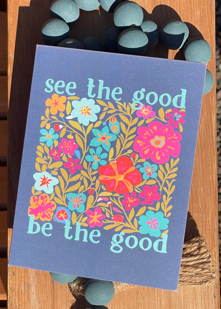Card with floral design and motivational text on a wooden surface