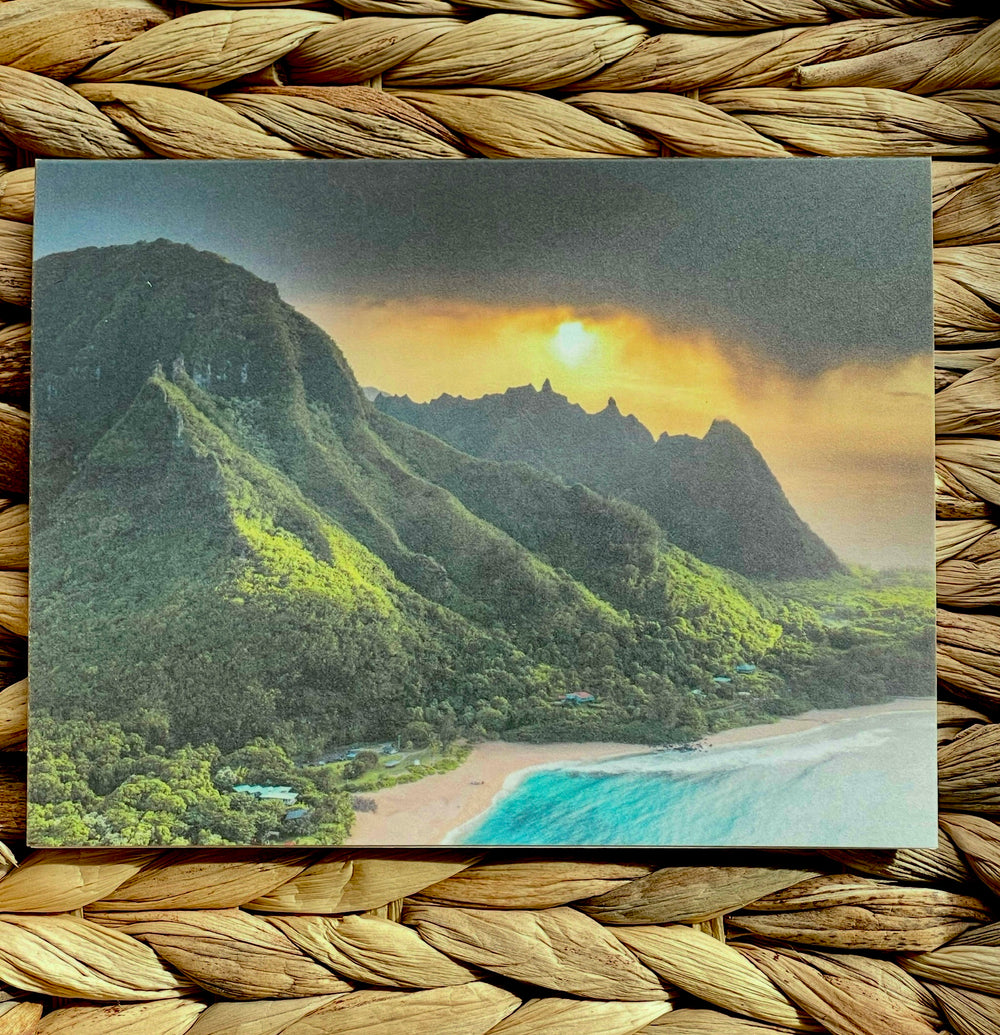 Scenic view of tropical mountains and beach with sunset, framed by woven material.