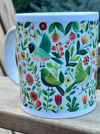 Mug with bird and floral pattern on a wooden surface