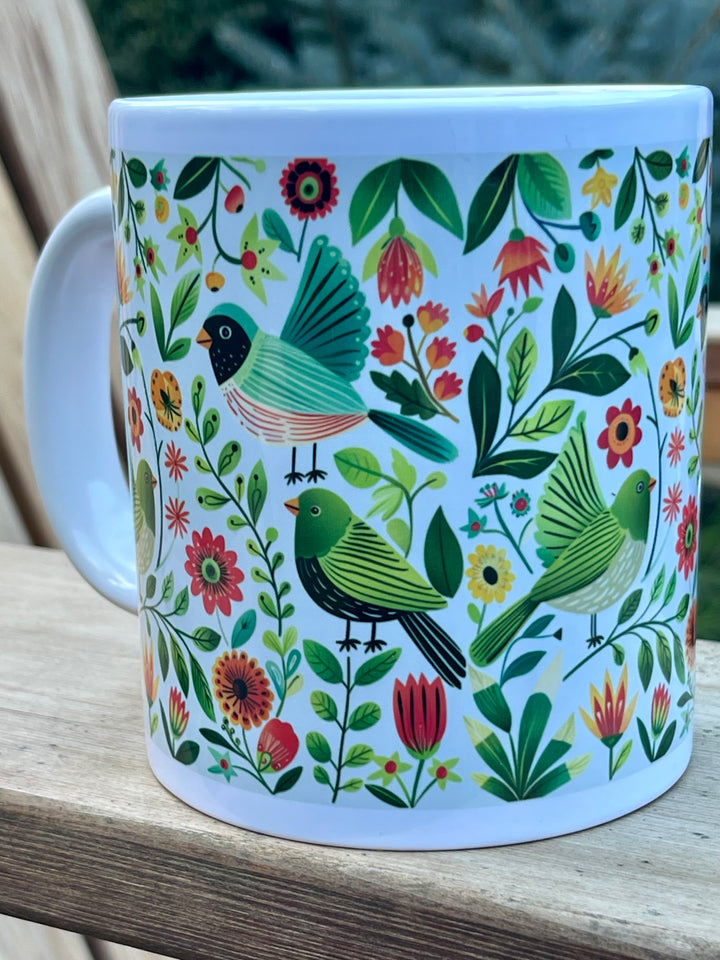 Mug with bird and floral pattern on a wooden surface