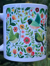Mug with colorful bird and floral pattern on a white background