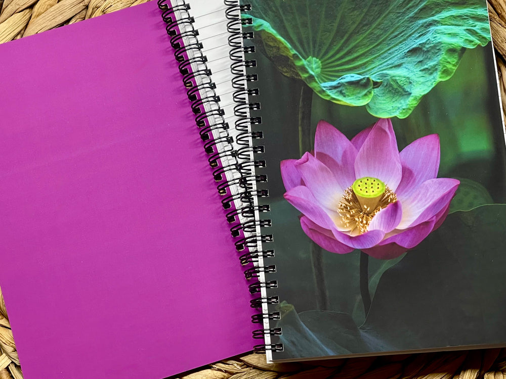 Purple notebook with a spiral binding featuring a pink lotus flower on the cover.