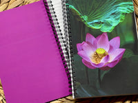 Purple notebook with a spiral binding featuring a pink lotus flower on the cover.