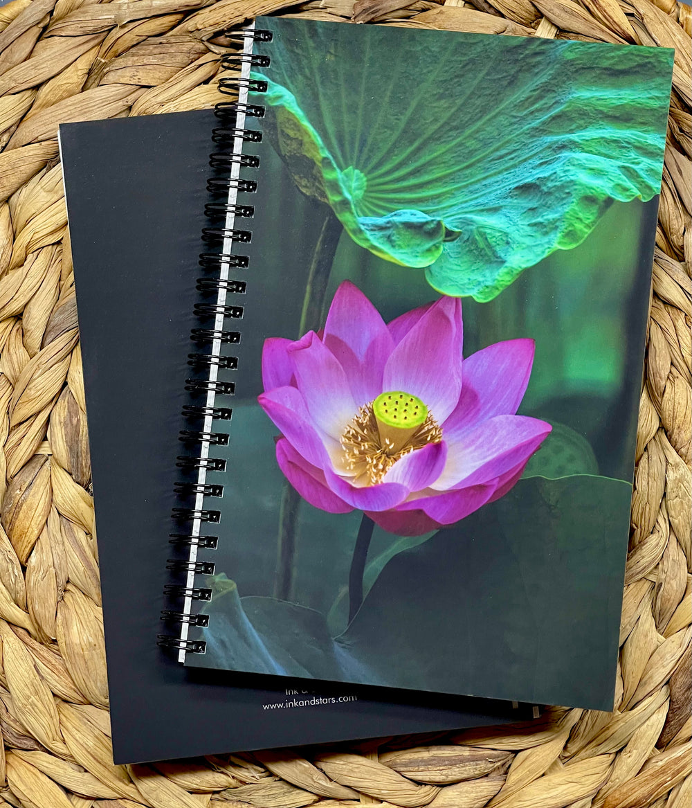Notebook with a pink lotus flower design on a woven surface
