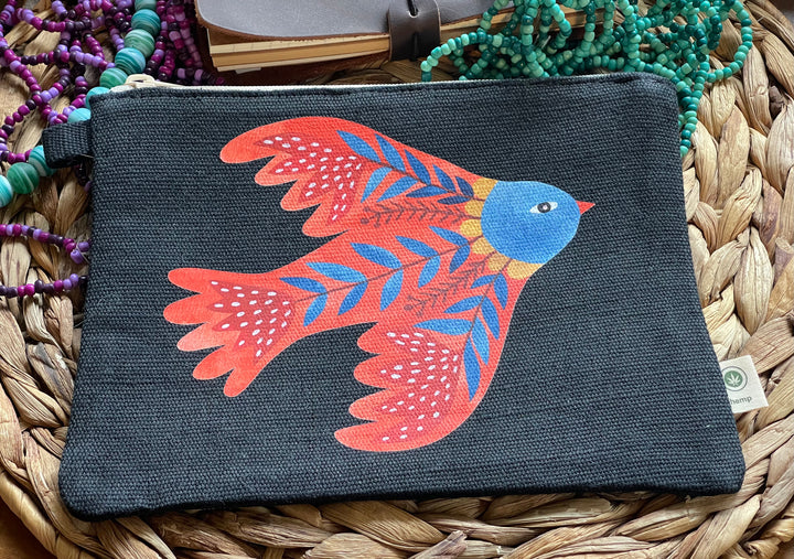 Black pouch with a colorful bird design on a woven surface