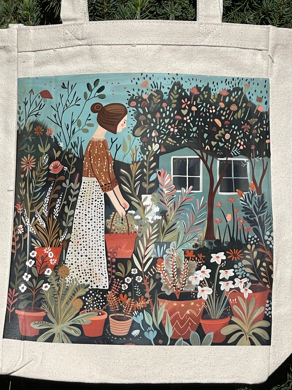Tote bag with folk art style  illustration of a woman tending to her plants in her yard.