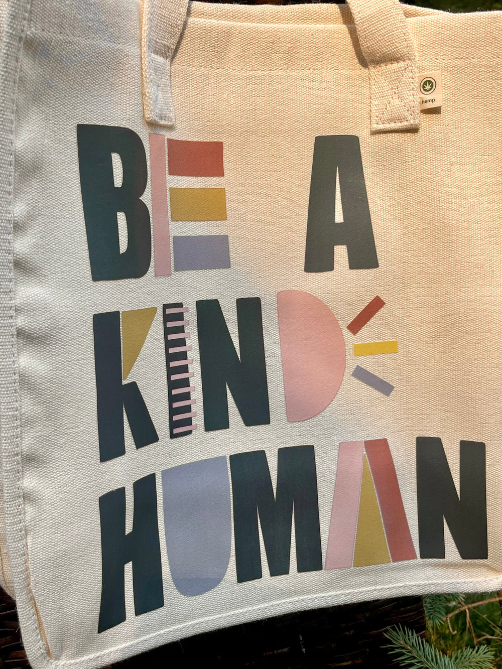 Tote bag with “Be A Kind Human” in playful graphic text.