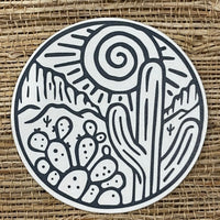 Round sticker with outline drawing of desert plants.