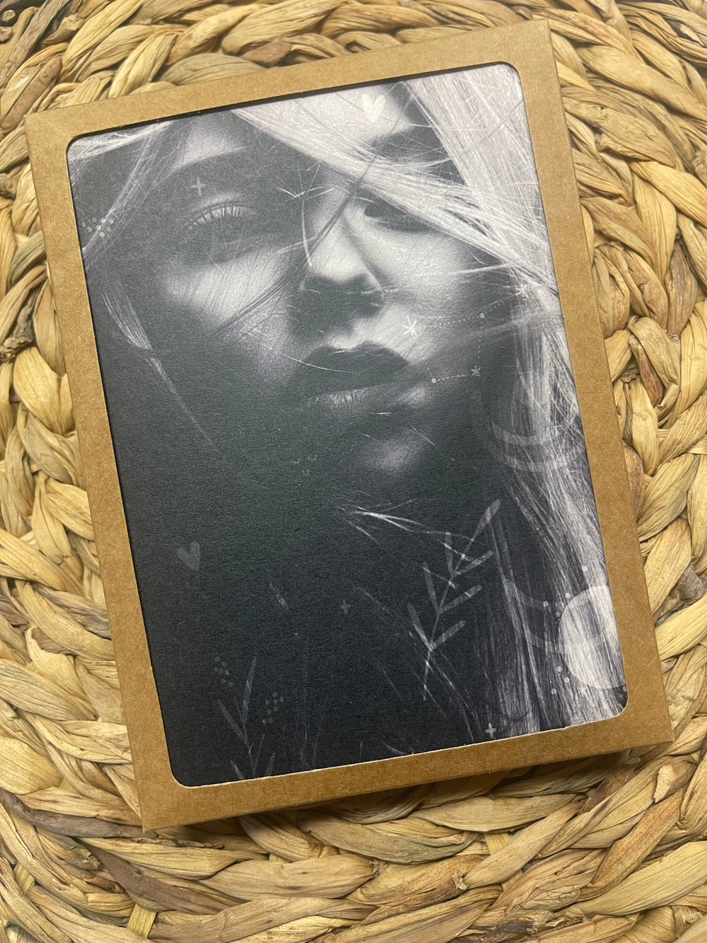Greeting cards in display box, featuring black and white image of young bohemian woman.