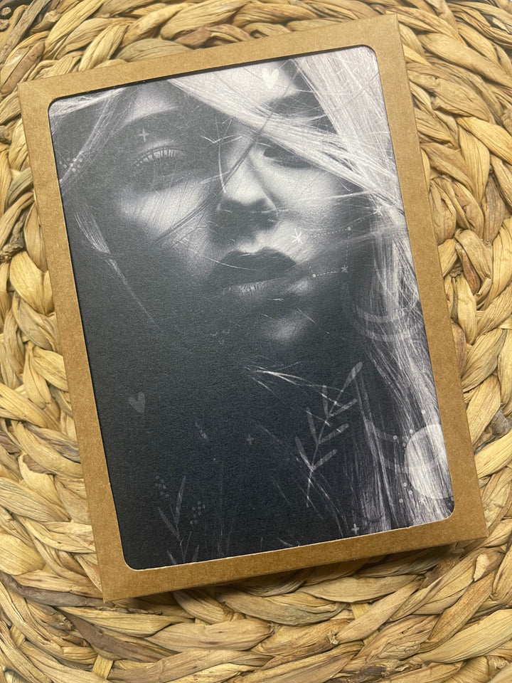 Greeting cards in display box, featuring black and white image of young bohemian woman.