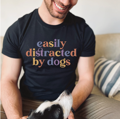 “Easily Distracted By Dogs” graphic on black short sleeve tee shirt.