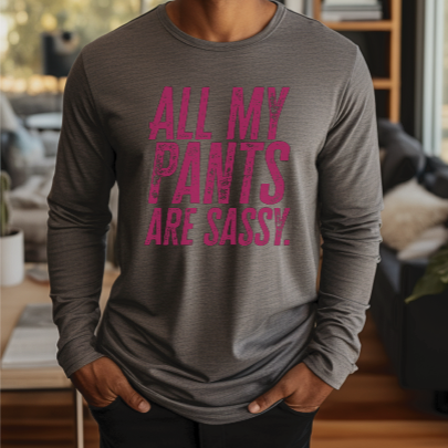 Young man wearing a long sleeve dark grey tee with “All My Pants Are Sassy” graphic.