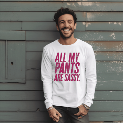 Young man wearing a long sleeve white tee with “All My Pants Are Sassy” graphic.