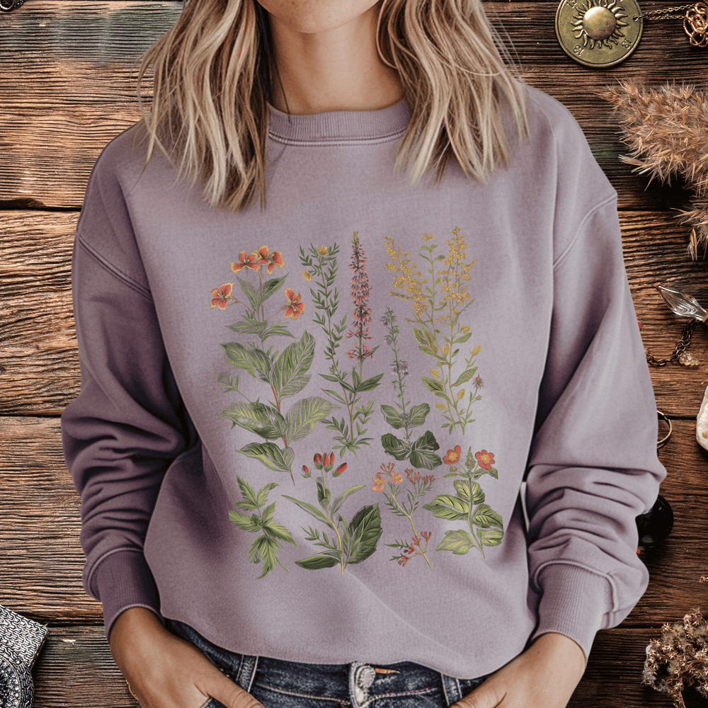 Person wearing a purple sweatshirt with floral designs in front of a wooden surface